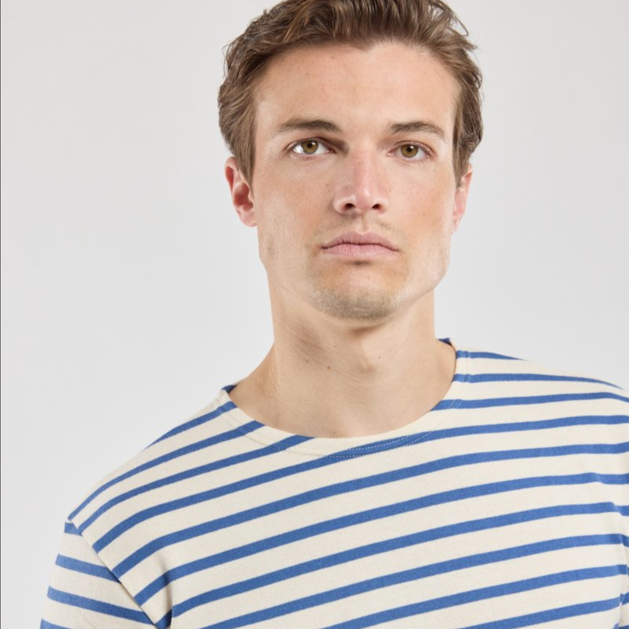 A man wears a marinere shirt with navy stripes