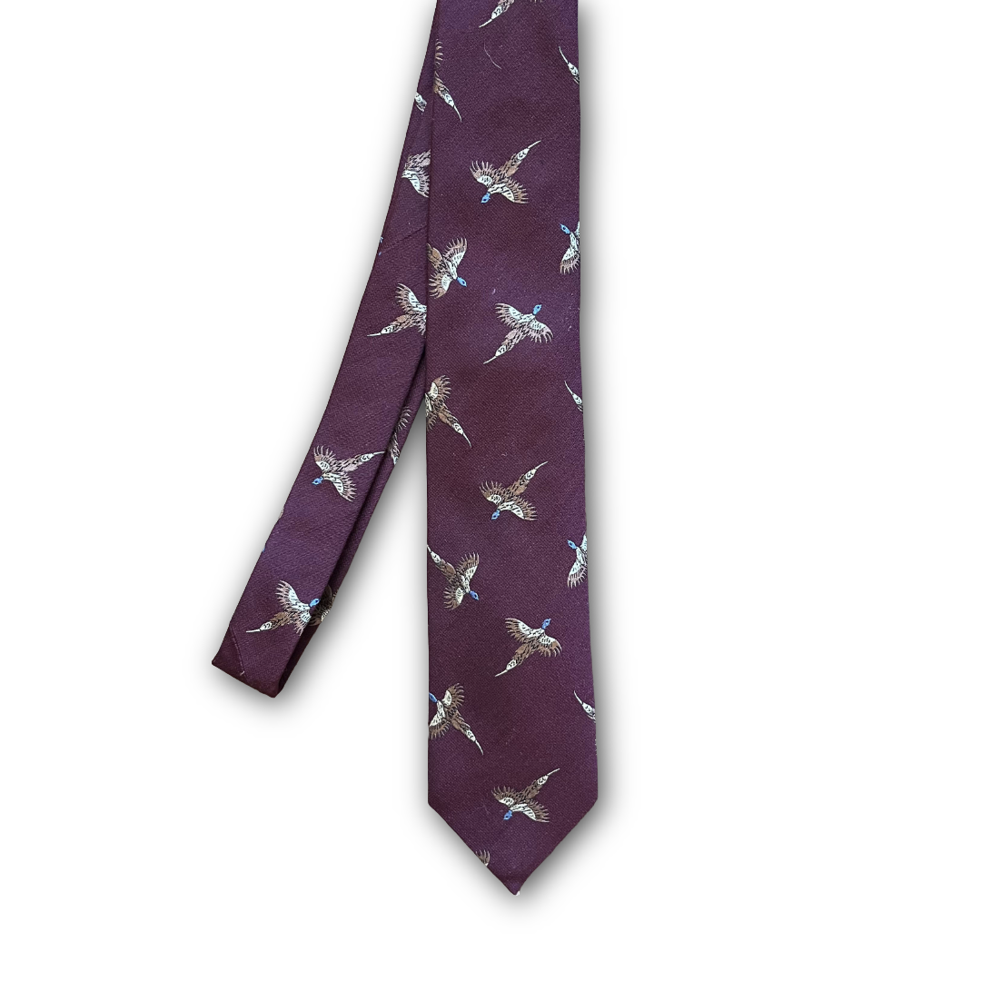 A burgundy necktie featuring a repeating pattern of flying birds in beige, brown, and light blue, displayed against a plain white background.