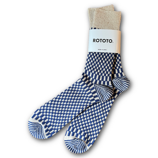 Pair of blue and white checkered socks with beige label on a white background