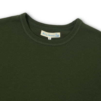Close-up of a dark green crewneck t-shirt showing the inner neck label 