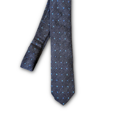 A brown textured necktie with a pattern of small light blue and medium blue dots, shown against a plain white background.