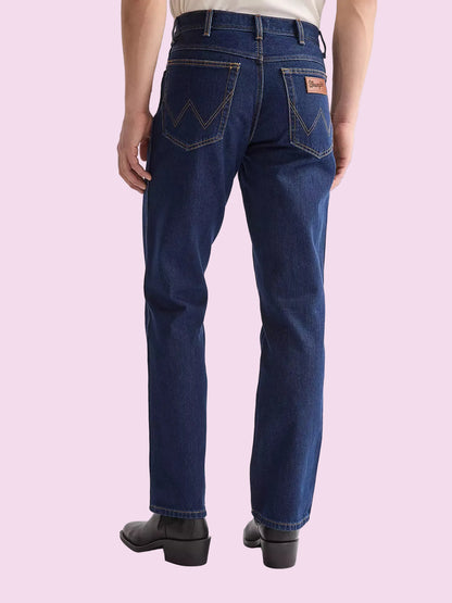 Person wearing blue jeans with a visible brand logo on a white background
