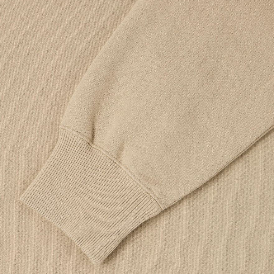 Close-up of a beige sweater sleeve on a matching background