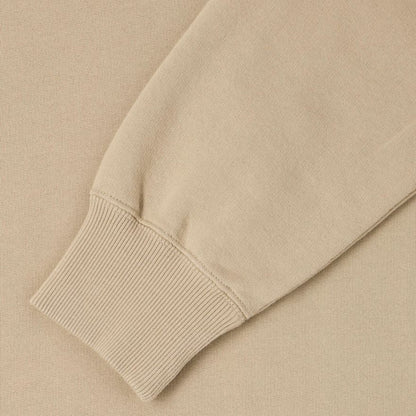 Close-up of a beige sweater sleeve on a matching background