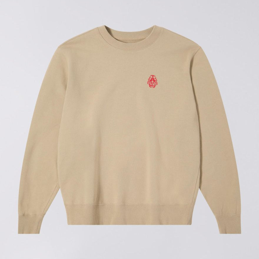 Beige sweater with a red logo on a light gray background