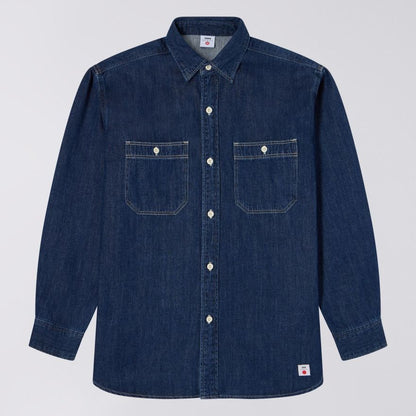 Blue denim shirt with two front pockets on a light gray background