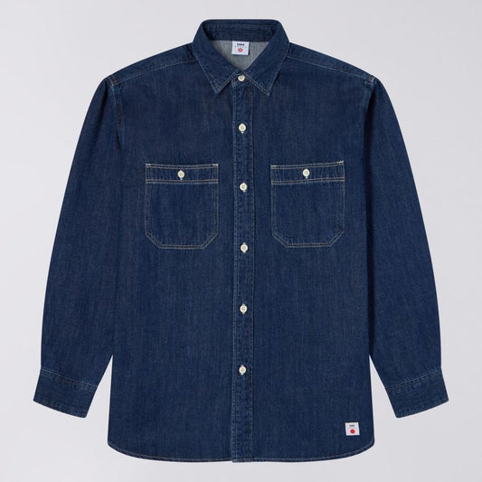Blue denim shirt with two front pockets on a light gray background