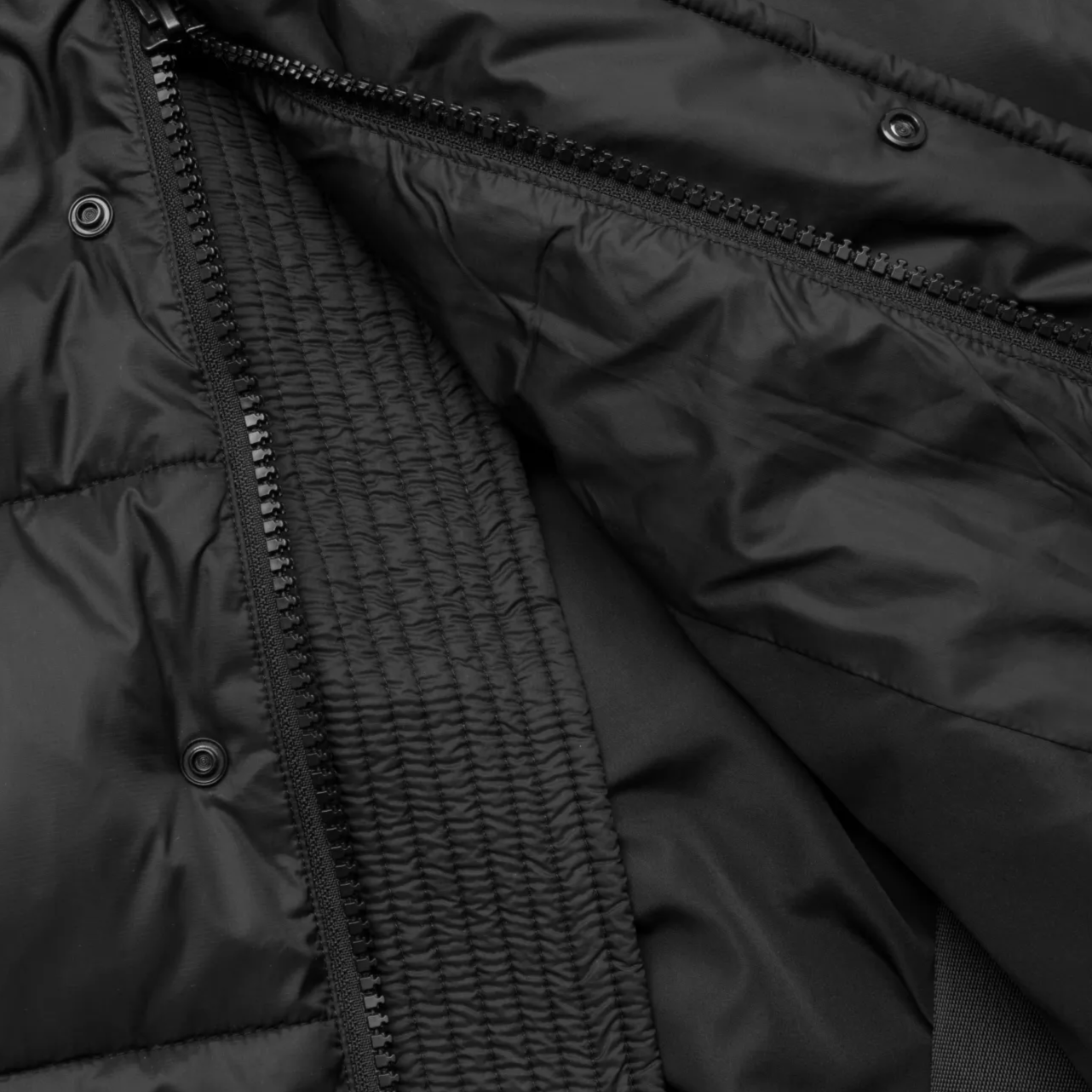 Close-up of a black jacket with zipper and button details