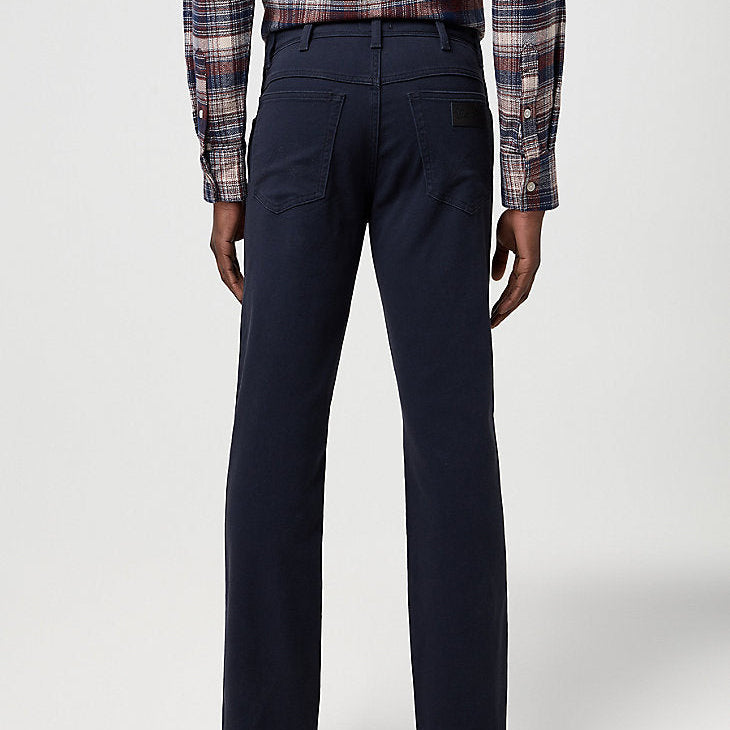 Person wearing navy pants and a plaid shirt on a white background