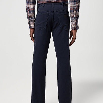 Person wearing navy pants and a plaid shirt on a white background