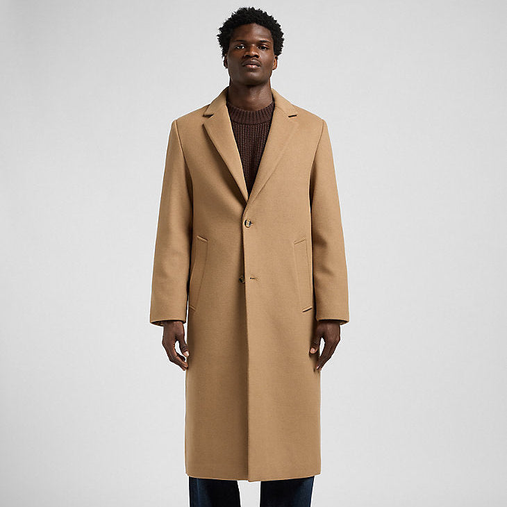 Man wearing a beige overcoat on a white background