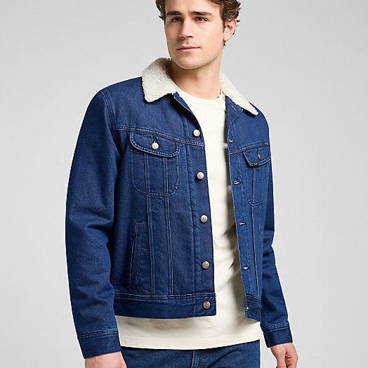 Man wearing a blue denim jacket with white collar on a gray background