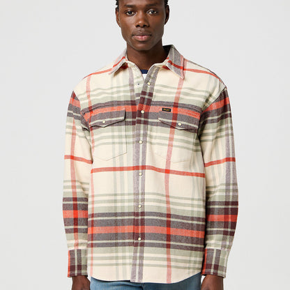 Man wearing a plaid shirt with red and gray patterns on a light gray background