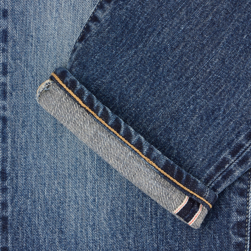 Close-up of blue denim fabric with a rolled hem