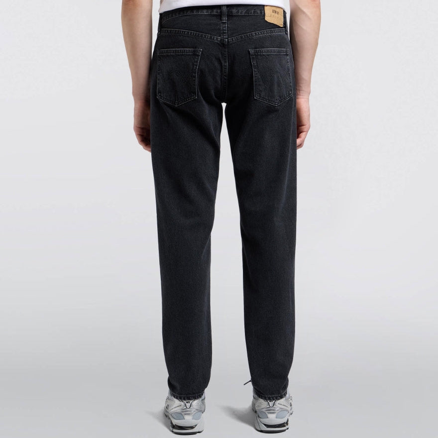 Person wearing black jeans on a white background