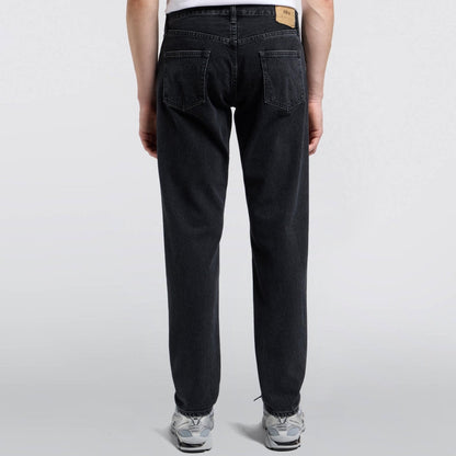 Person wearing black jeans on a white background