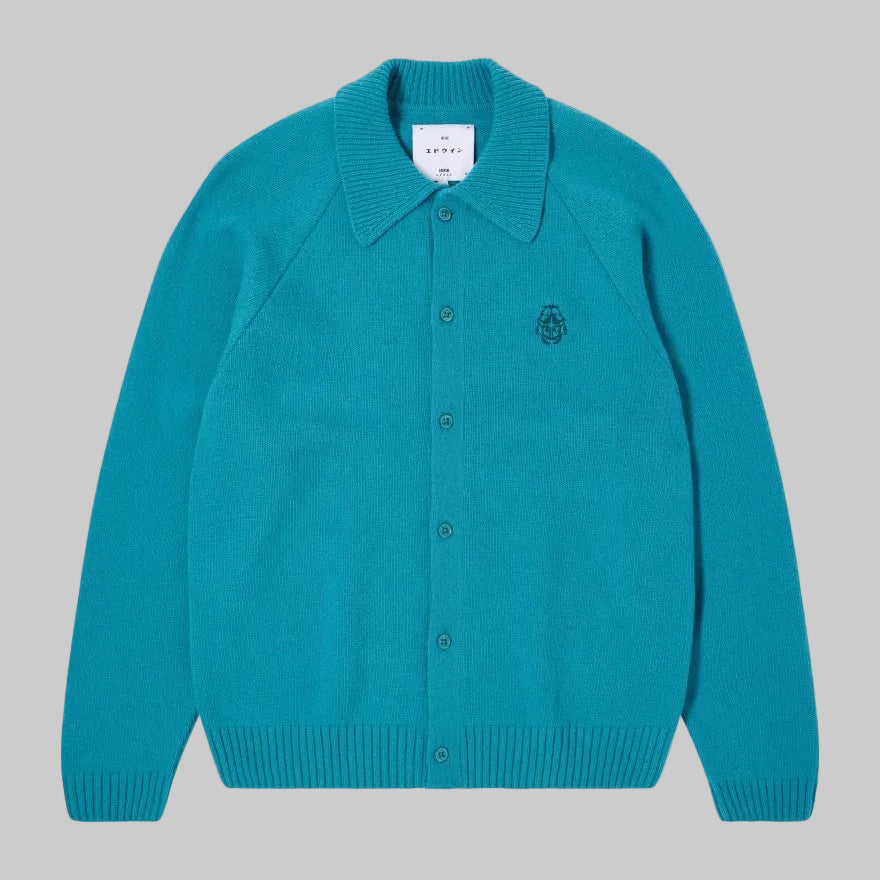 Teal cardigan with a brand label on a light gray background