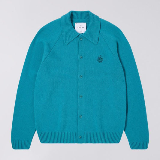 Teal cardigan with a brand label on a light gray background