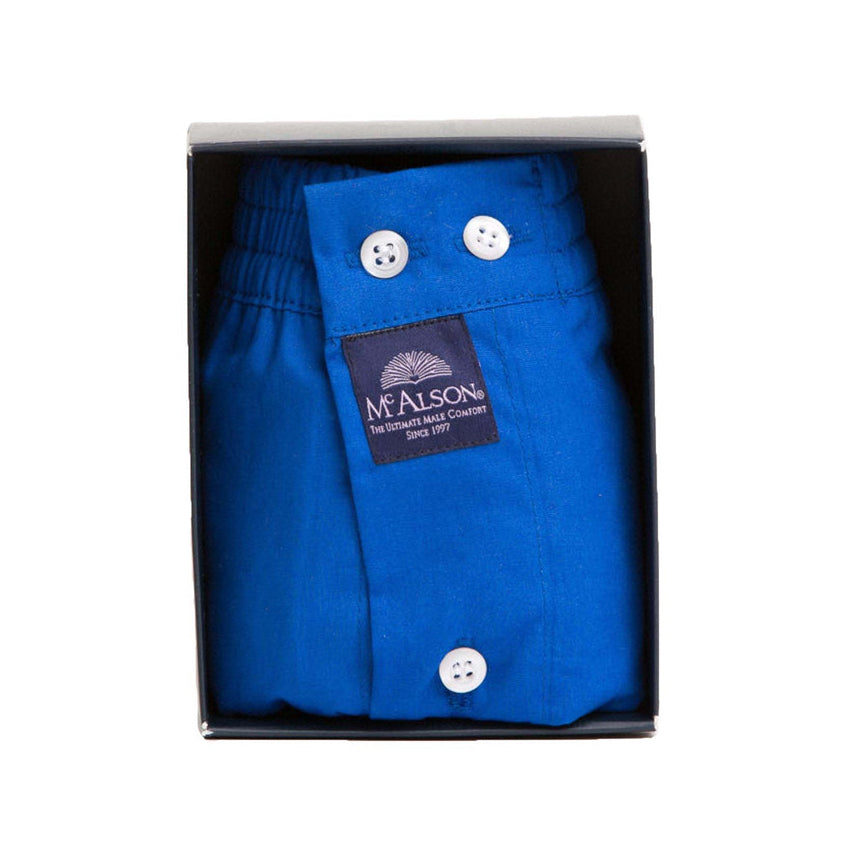 Royal blue boxer folded inside a black gift box, featuring white buttons and a black brand label reading 'McALSON'.