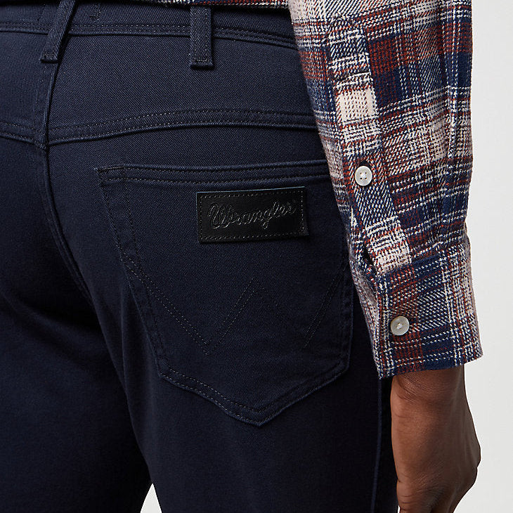 Navy pants with a plaid shirt on a light gray background