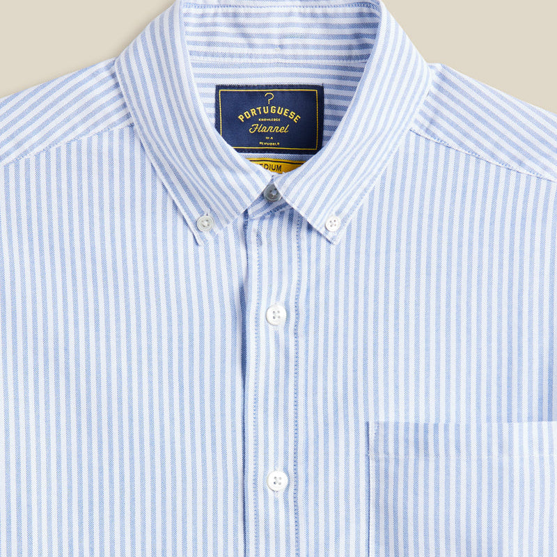 Blue and white striped shirt with a Portuguese Flannel label on a beige background