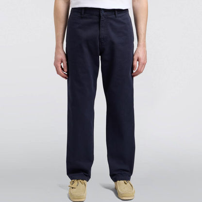 Person wearing navy pants and beige shoes on a white background