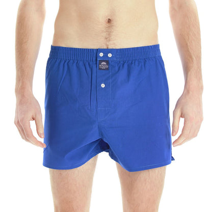 A man wearing royal blue boxer with a buttoned front and elastic waistband, shown from the waist to mid-thigh against a plain white background.