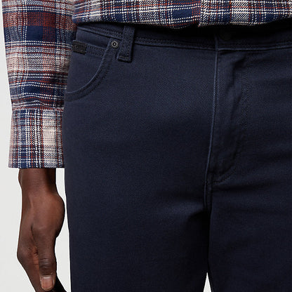 Navy pants worn with a plaid shirt on a light gray background