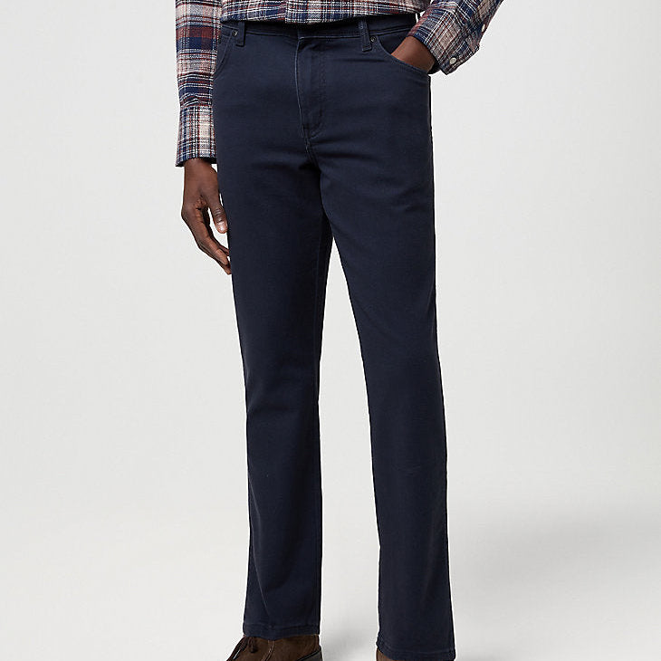 Person wearing navy pants with a plaid shirt on a white background