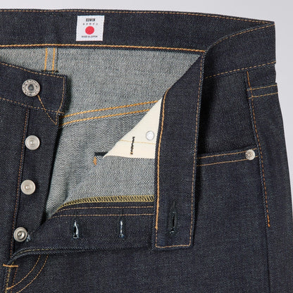 Close-up of dark blue denim fabric with a brand label on a gray background