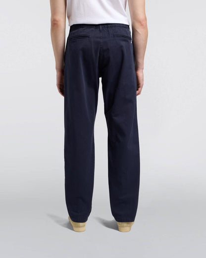 Navy pants worn by a person on a light gray background