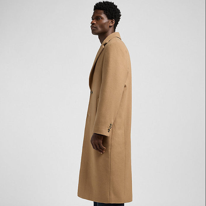 Man wearing a beige trench coat on a white background