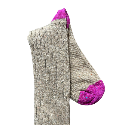 Regent Tailoring merino wool boot socks in beige with vibrant pink toe and heel contrast on a rustic wooden floor.
