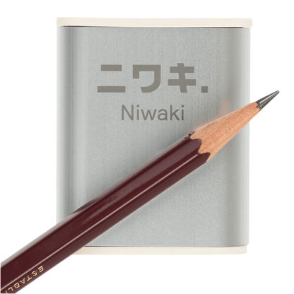 Regent Tailoring Niwaki aluminium pencil sharpener with rice resin base and a dark wood pencil on a white background