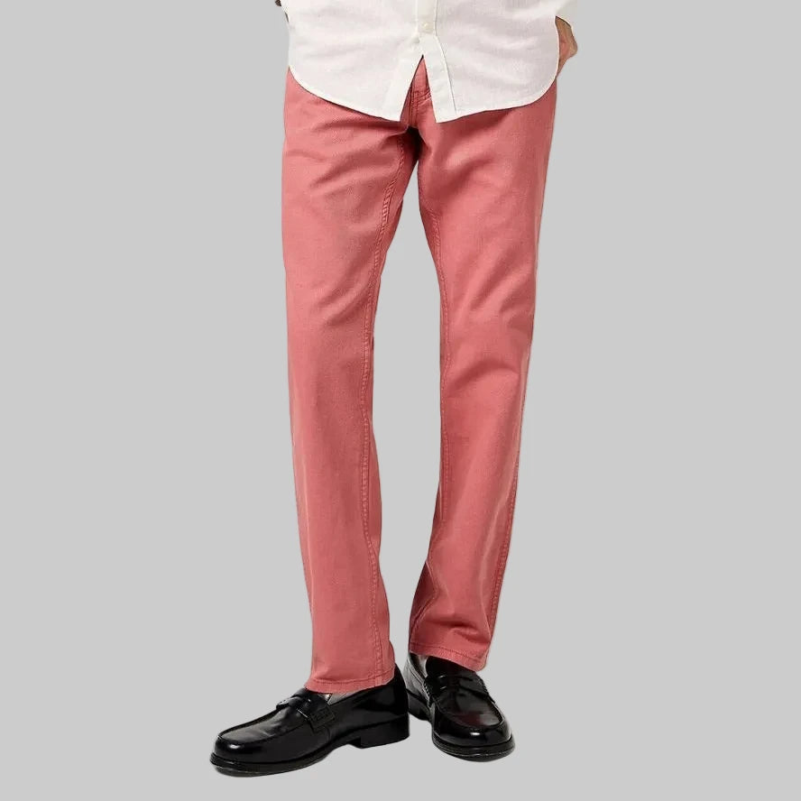 Man wearing a white button-up shirt and pink pants on a white background