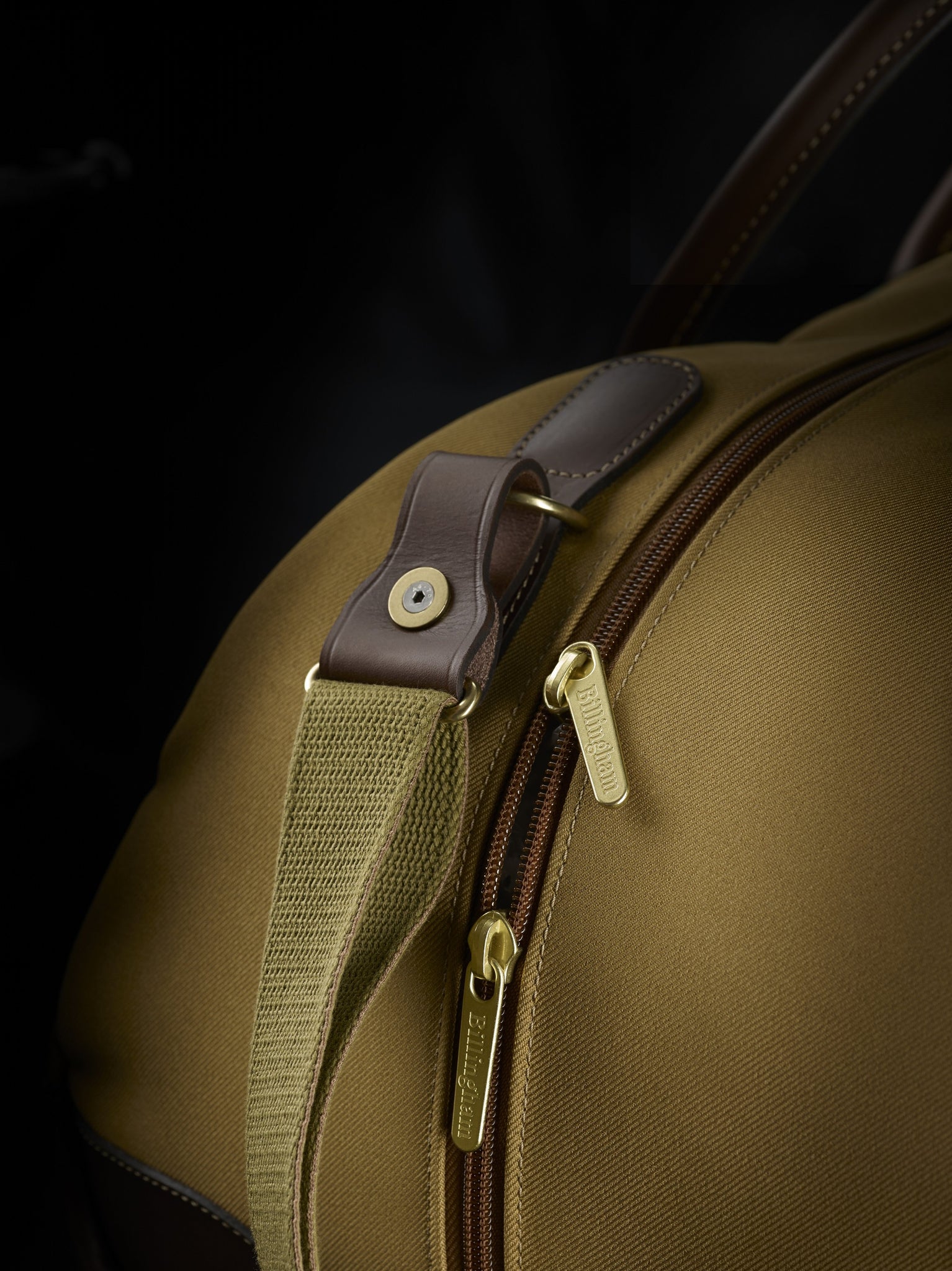 Travel bag weekender size in khaki from Great British travelware experts Billingham, featuring waterproof composition, real grain leather, brass fittings and 5-year guarantee.