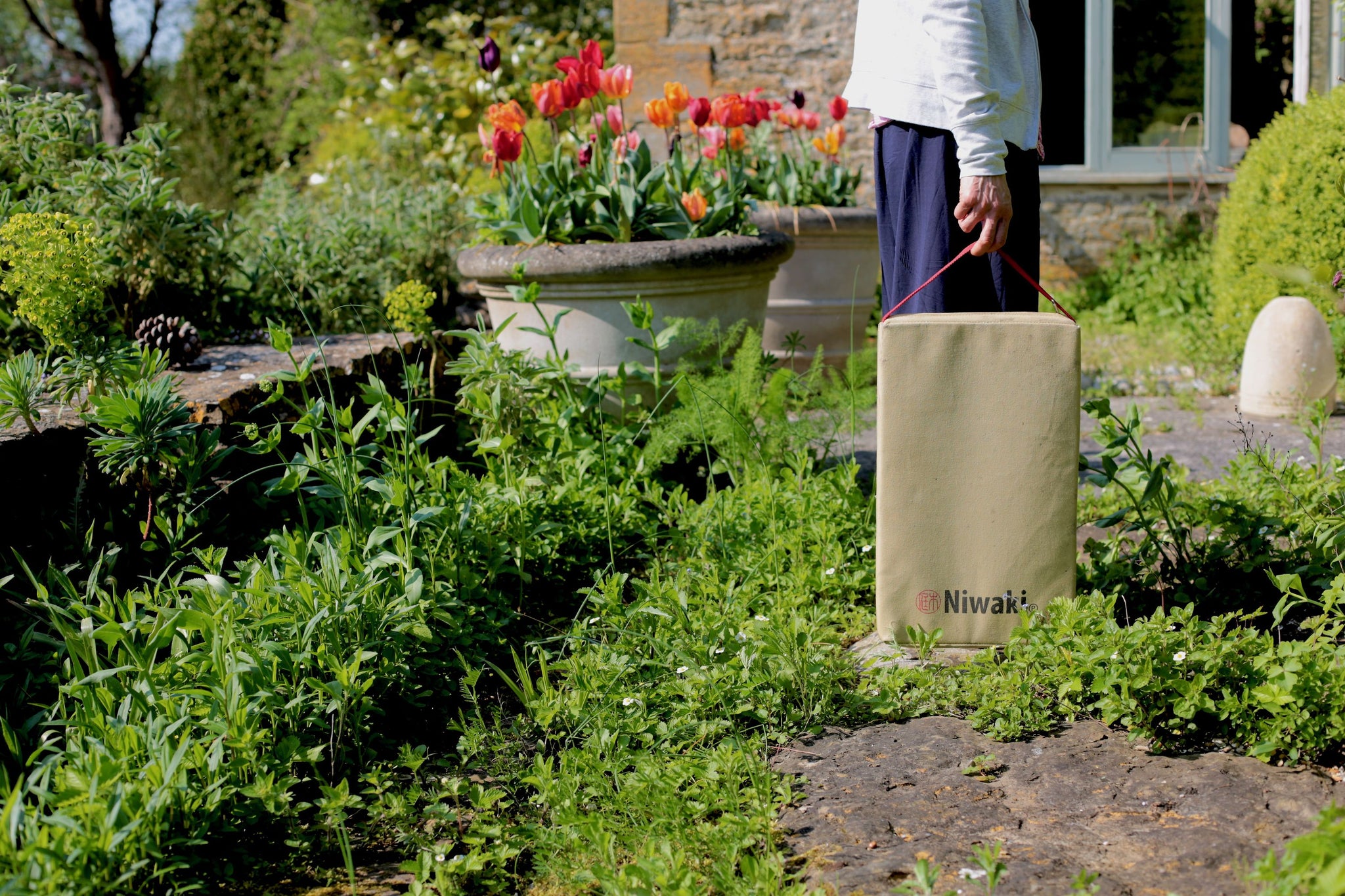Heavy-duty, protective garden kneeler for cushioning and protecting knees and legs when working in the garden, by masterful Japanese Garden brand Niwaki, featuring water-resistant tan canvas.