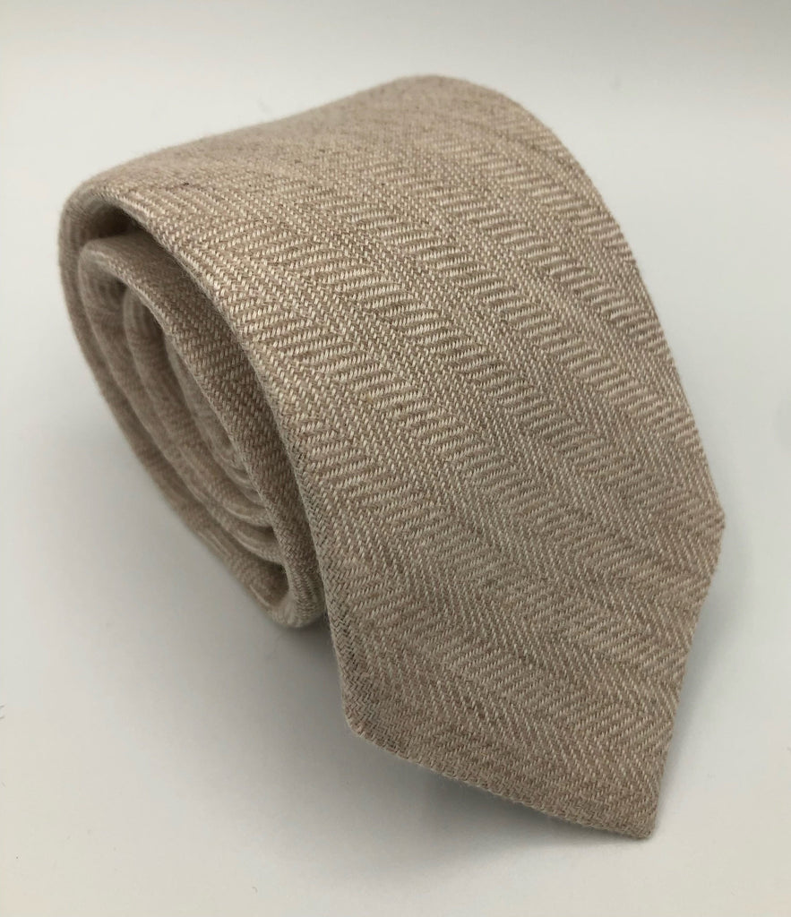 A luxury wool and silk tie designed by and handmade exclusively for Regent. Smart, subtle beige is given a kick by elegant herringbone. Excellent for everyday and special occasions alike.