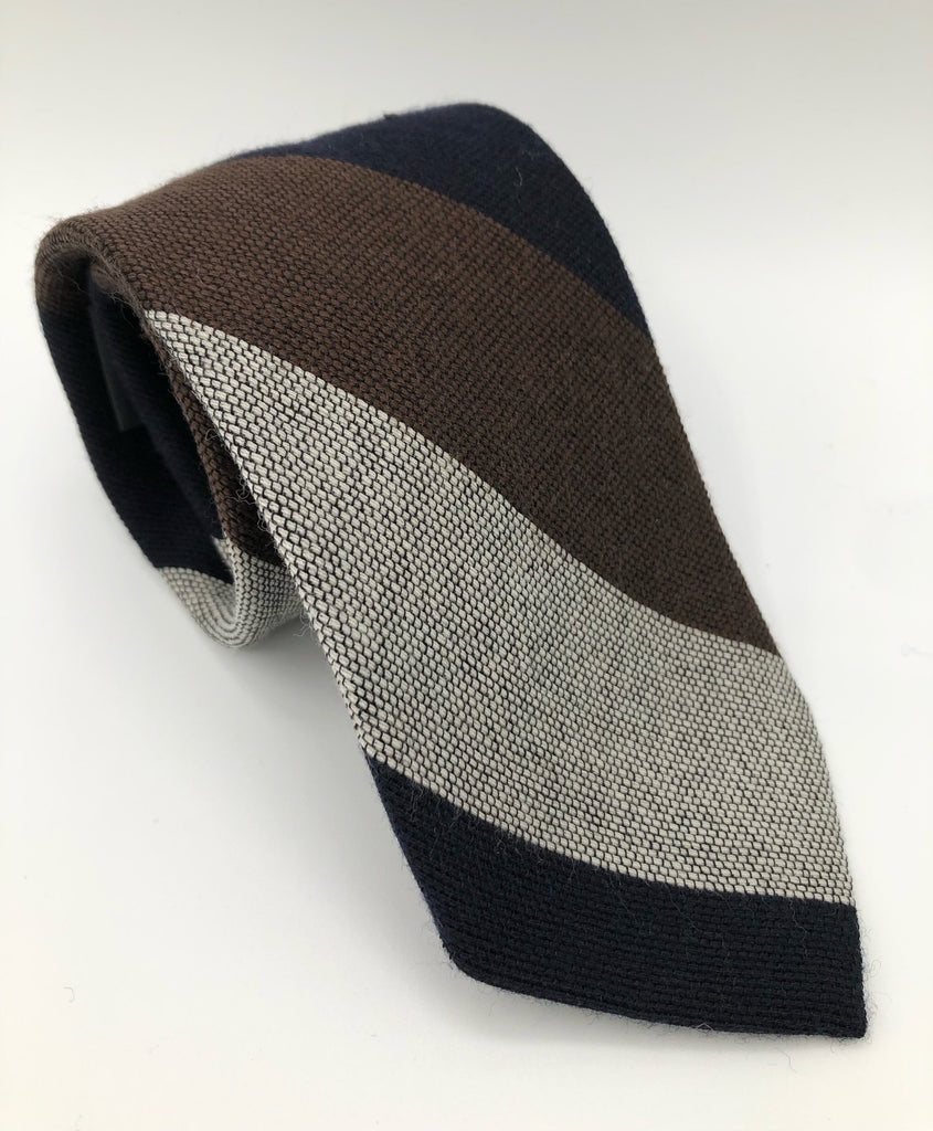 A luxury wool and silk tie designed by and handmade exclusively for Regent. An organic, primordial mixture of colours meted out in dynamic ruled stripes. 