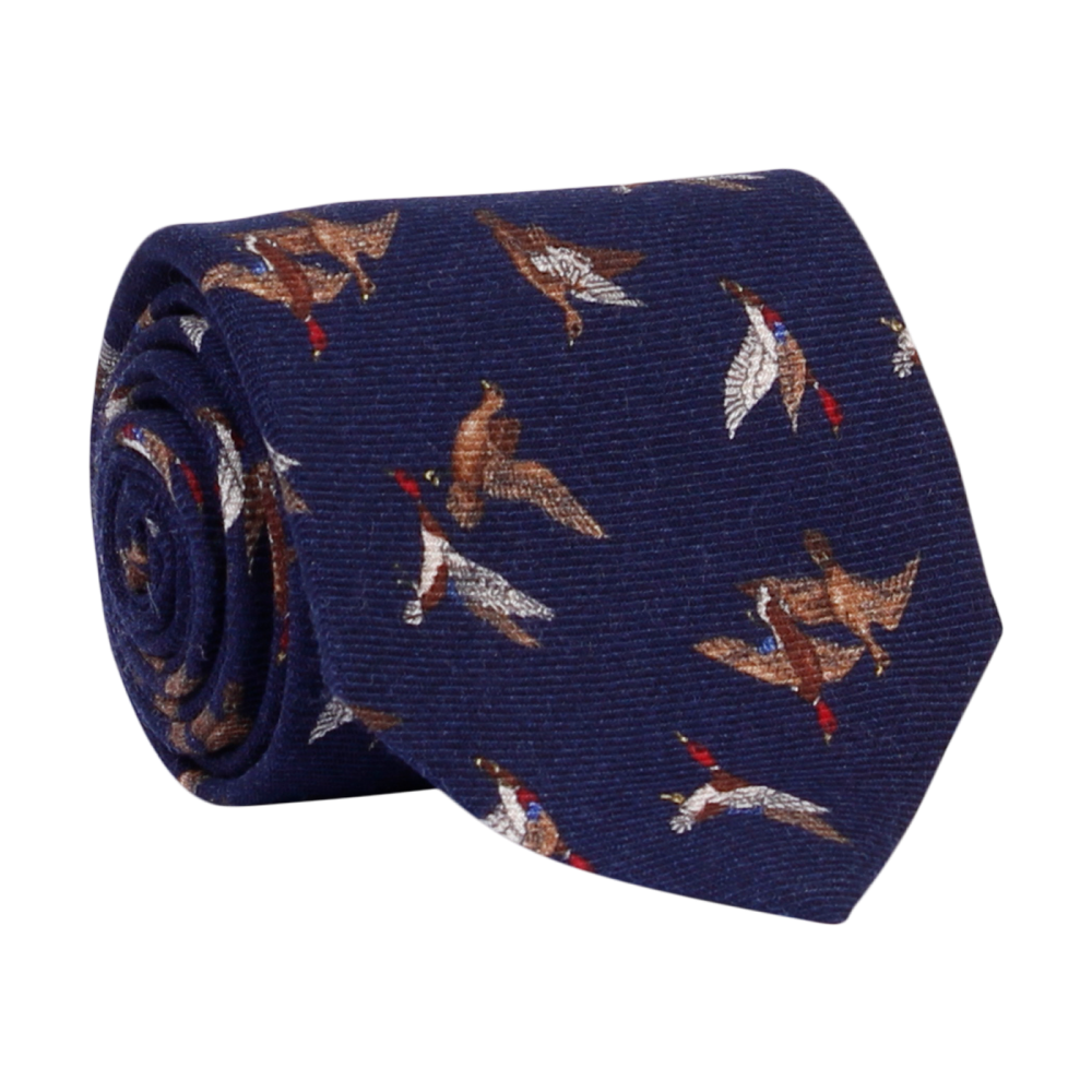 A luxury wool and silk tie designed by and handmade exclusively for Regent. A crisp peaceful wintery night navy is traversed by a flock of wild ducks. 