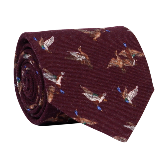 A luxury wool and silk tie designed by and handmade exclusively for Regent. A stormy bordeaux is traversed by a flock of wild ducks.