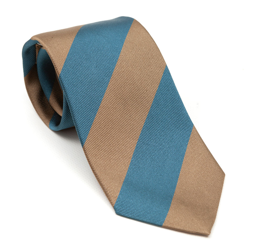 A luxury silk tie designed by and handmade exclusively for Regent. Rich Mediterranean blue and burnt gold stripes combine for a peaceful, calming finish - great with a black or brown suit.